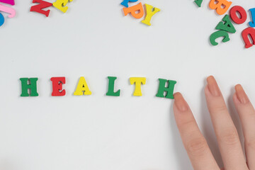 Female hands lay out the word health from colored letters