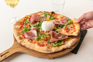Pizza with mozzarella and raw ham