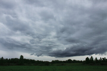 Naklejka na ściany i meble Dark rain clouds above the field