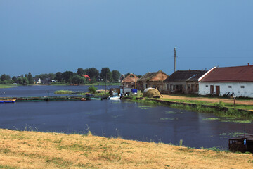 Fototapeta na wymiar Village before the thunderstorm with the dark blue sky