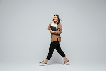 Fashionable, stylish. Young woman in casual wear on gray background. Bodypositive character, feminism, loving herself, beauty concept. Plus size businesswoman during paperwork. Inclusion, diversity.