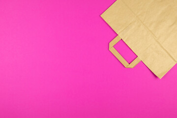 Top view of kraft paper bag on pink background.  Text space