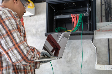 Young network administrator pluging in wires. Electrician engineer tests electrical installations...