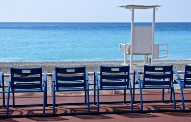 Tipiche sedie in fronte al mare della Costa Azzurra e torre assistenza bagnanti