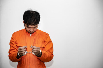 Prisoner in orange robe concept,Portrait of asian handsome man in Prison uniforms,Bandit has a lot...