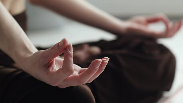 A close-up of women's hands. Girl practices yoga