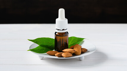 almonds in a white plate and glass bottles with oil on a wooden table
