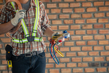 Fototapeta na wymiar Air Conditioning Technician and A part of preparing to install new air conditioner. Technician vacuum pump evacuates and checking new air conditioner