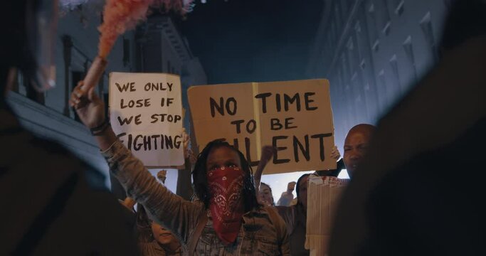Group of people protesting with smoke grenades. Group of men and women on anti-government protest at night.
