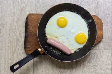 Fried eggs with sausage in a pan