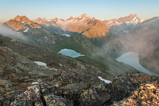 While the Finsteraarhorn and the Lauteraarhorn catch the first rays of the sun, the Unteraar glacier and lake Grimsel below are still shrouded in darkness.