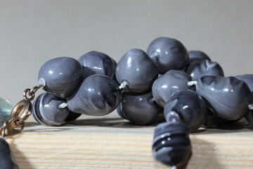Cheap Dark Grey Plastic Beads, on a white thread,, close up Macro