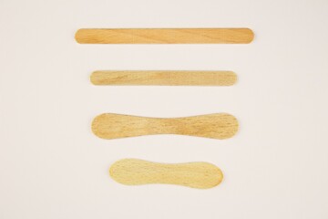 Collection of four sticks for popsicles isolated on a white background.Straight and round shaped stick from frozen popsicles. Wood waste or material for further use. Upcycling.