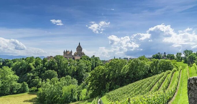 Time lapse du splendide ch&acirc;teau de Vufflens-le-Ch&acirc;teau entour&eacute; de vignes et de foret au soleil dans le canton de vaud en suisse romande pr&egrave;s de Lausanne dans un ciel bleu avec des nuages blancs
