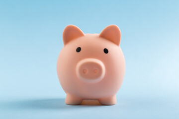 pink piggy bank on blue background.  The concept of saving money or savings, investment