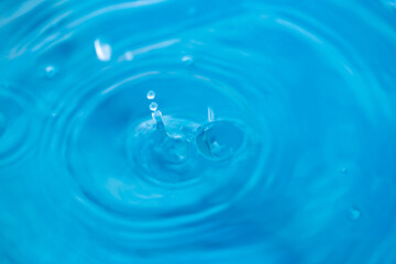 The round transparent drop of water, falls downwards. Selective focus.