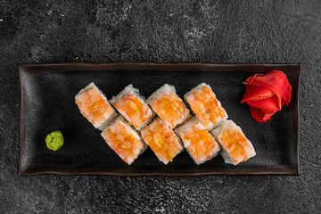 japan sushi rolls with salmon, shrimps and smoked eel with cream cheese on black platter