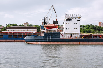 Cargo barge ships on the river near the port.