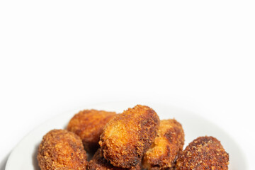 assortment of crispy, yet creamy inside, coquettes on a dish isolated in white