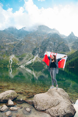 young pretty woman with poland flag in mountains near lake