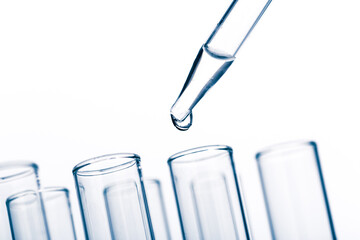 pipette with a drop and scientific laboratory test tubes in a research laboratory.