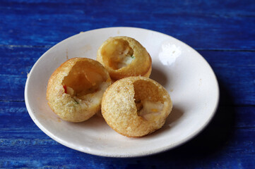Close Up of Panipuri or Golgappa in Plate Isolated on Blue Wooden Background, Also Known as Phuchka, Paani Patashi, Gup Chup, Indian Street Food