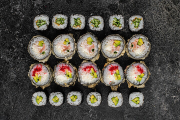 Traditional Japanese food - sushi, rolls and sauce on grey metal background. Top view