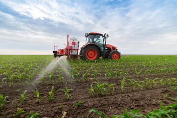 Tractor spraying pesticides at corn fields