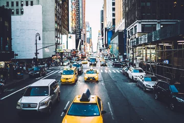 Papier Peint photo TAXI de new york Rue animée du centre-ville avec de hauts immeubles et de la publicité sur les façades et des voitures circulant sur la route, des taxis jaunes et des automobiles se déplaçant dans la rue à New York pendant la journée avec un trafic de pointe