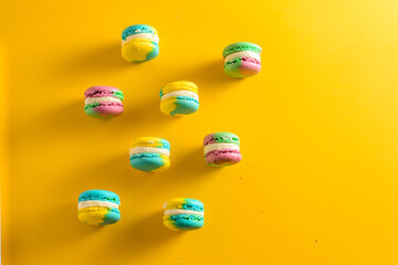 colorful macarons with a space for text on yellow