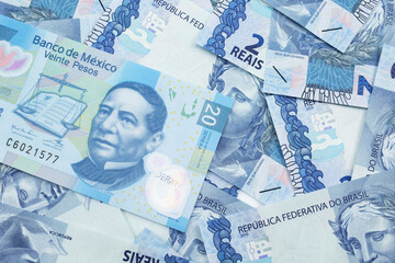 Fototapeta premium A close up image of a blue, twenty Mexican peso note on a bed of blue, two real notes from Brazil