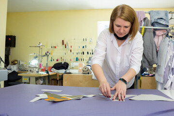 Girl fashion designer puts chalk details on patterns