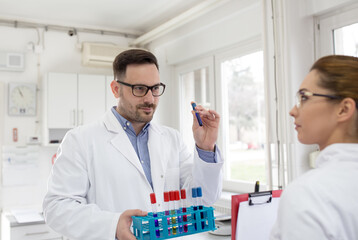 Doctor and nurse with test tubes in laboratory