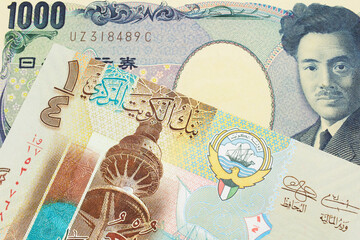 A macro image of a Japanese thousand yen note paired up with a colorful, plastic quarter dinar from Kuwait.  Shot close up in macro.