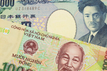 A macro image of a Japanese thousand yen note paired up with a colorful, plastic ten thousand dong note from Vietnam.  Shot close up in macro.