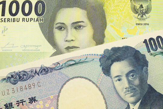 A macro image of a Japanese thousand yen note paired up with a green one thousand bank note from Indonesia.  Shot close up in macro.