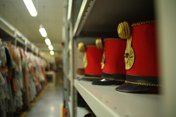 Vintage garment military hat red hard, on rack, storage, industrial, costumes, fancy dress, warehouse, retail store