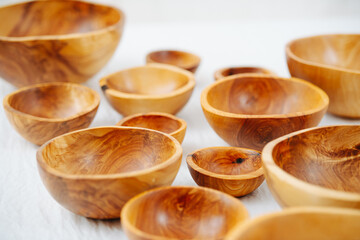 Variety of differently sized handmade wooden bowls on a white surface