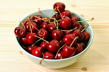 Obraz na płótnie Canvas Fresh red cherries in a porcelain cup, fruits of the summer season