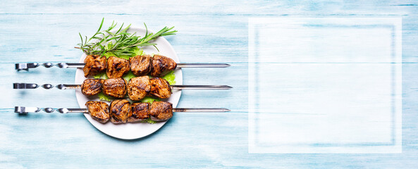 Cooked meat on skewers on a wooden background. Barbecue concept. top view
