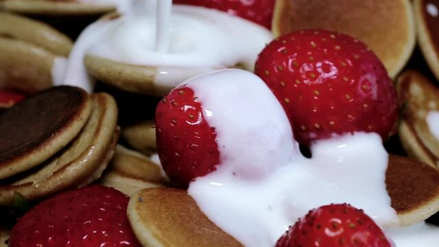 Homemade cereals mini pancake with yogurt, honey and strawberries on colorful background.
