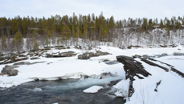 rapid waterfall flow in winter, national river waterfall of Maalselvfossen in Maalselv, northern Norway