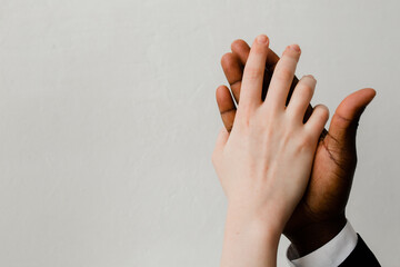 Two hands of different people by skin color and nationality touch each other for cooperation and friendship. Fight against racism