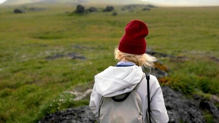 Back of a blond woman who is walking in the nature