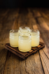 Yellow colored alcoholic shooters, or shot drinks on wooden table