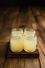 Yellow colored alcoholic shooters, or shot drinks on wooden table, copy space