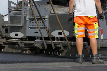 Fototapeta premium Schwarzdeckenfertiger baut Asphalt ein