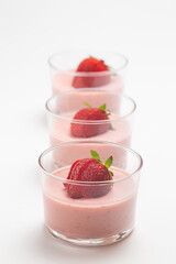 Strawberry panna cotta in glass cup and white background
