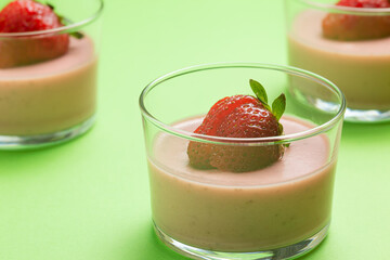 Strawberry panna cotta in glass cup and green background