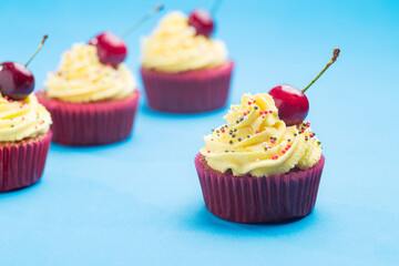 Cupcakes with whipped cream decorated with a cherry made without lactose